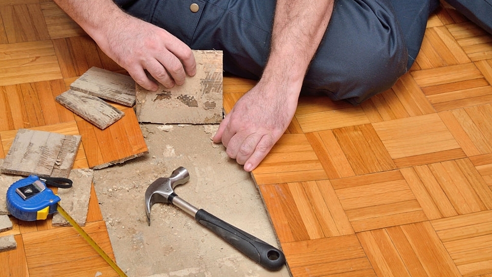 Worker removing damaged parquet