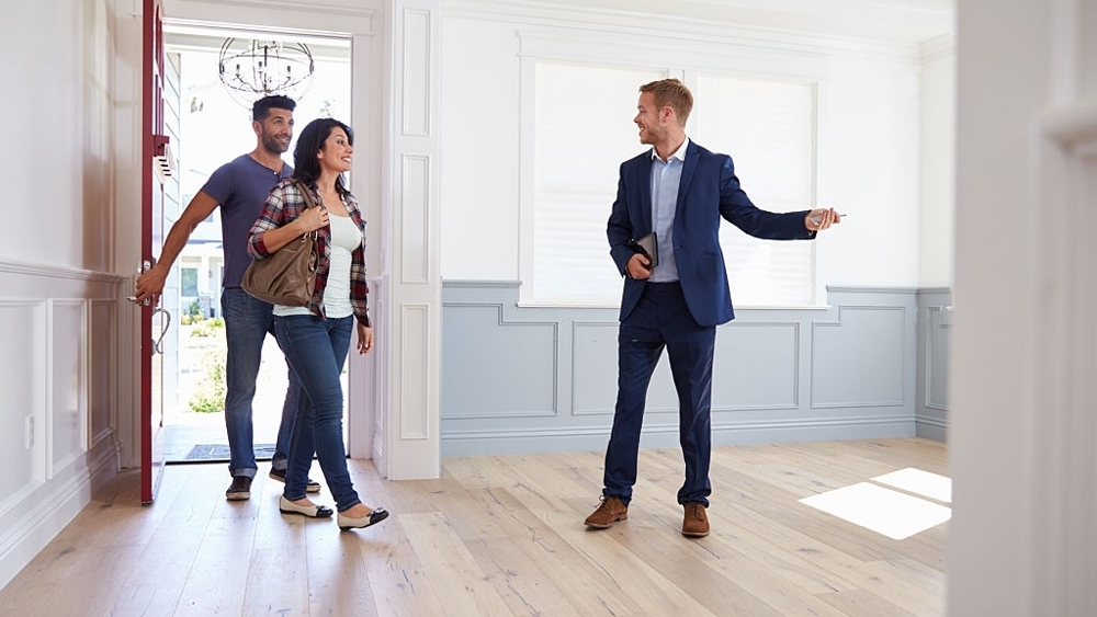 Realtor showing hispanic couple around new home