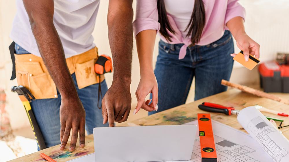 Couple using laptop planning for house renovation