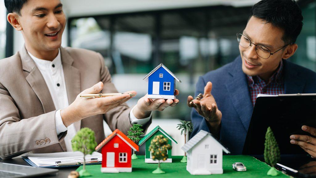Two men pointing to tiny house models
