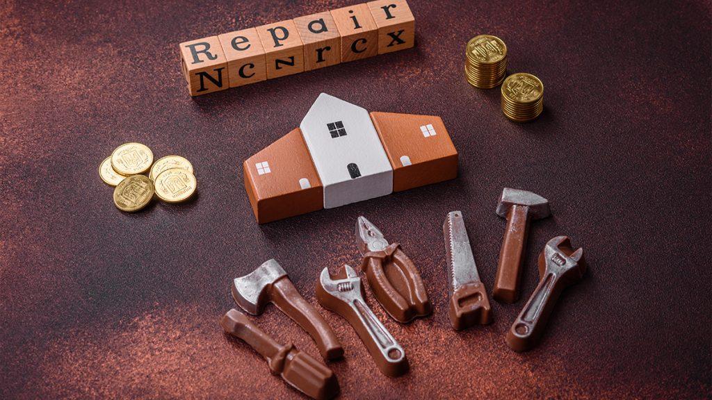 Home repair tools and a wooden house model