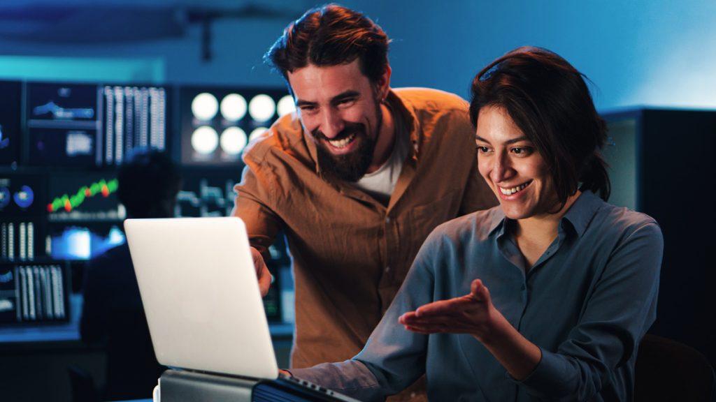 Happy business couple working on a laptop computer