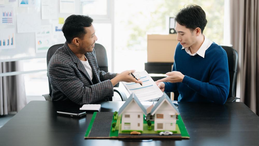 Real estate agent showing house contract to customer