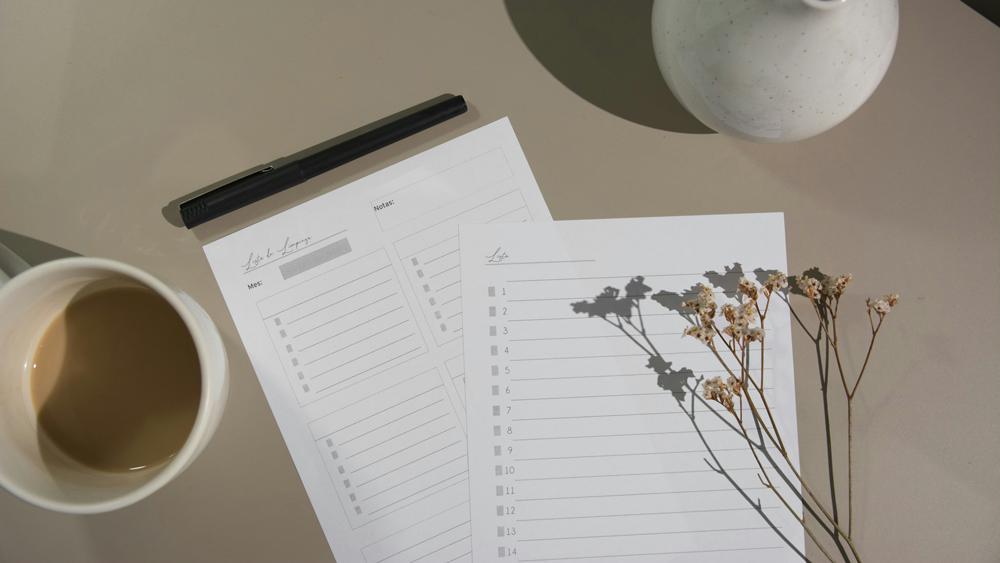 White papers beside a white ceramic mug